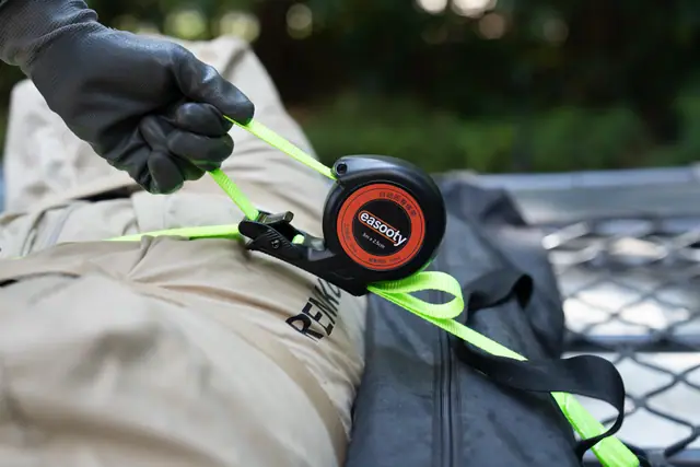 Sistema de amarre con recogida automática fijando una bolsa a una red de plataforma de camión
